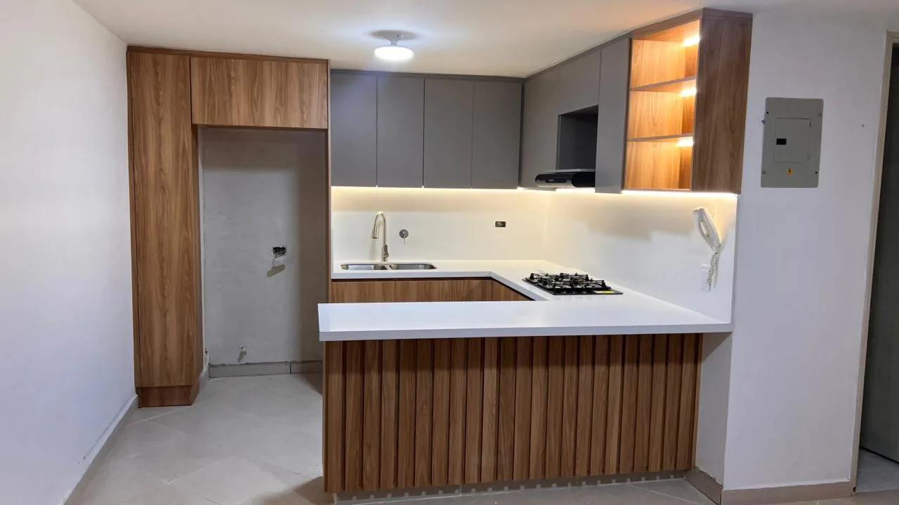 Fotografía de cocina construida en U con barra revestida en listones de madera y altos en taupe con iluminación LED